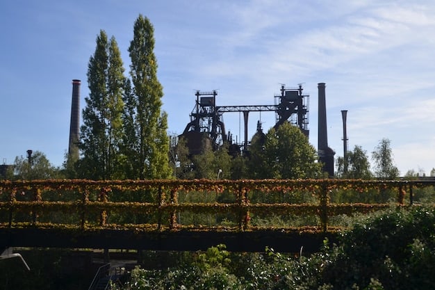 A photo showing a closed coal power plant with overgrown weeds and a cloudy sky in the background, symbolizing the transition away from fossil fuels.